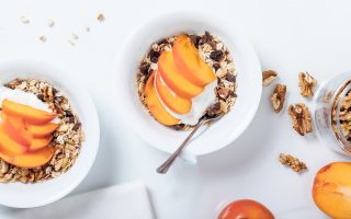 Foto van kommetjes met yoghurt, muesli en fruit van Peanuts & Nutmeg.