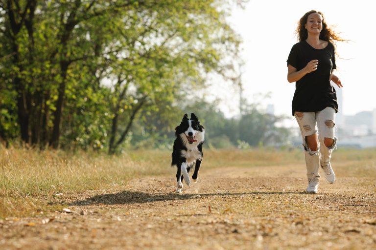 Foto van een vrouw die jogt met haar hond.