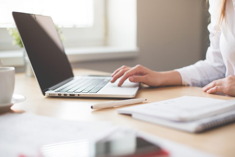 Foto van een vrouw die aan een bureau werkt.