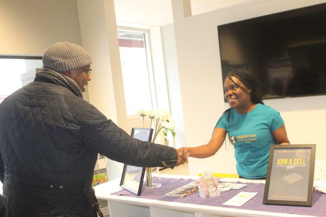 Usher welcoming someone to church at Pentecost International.