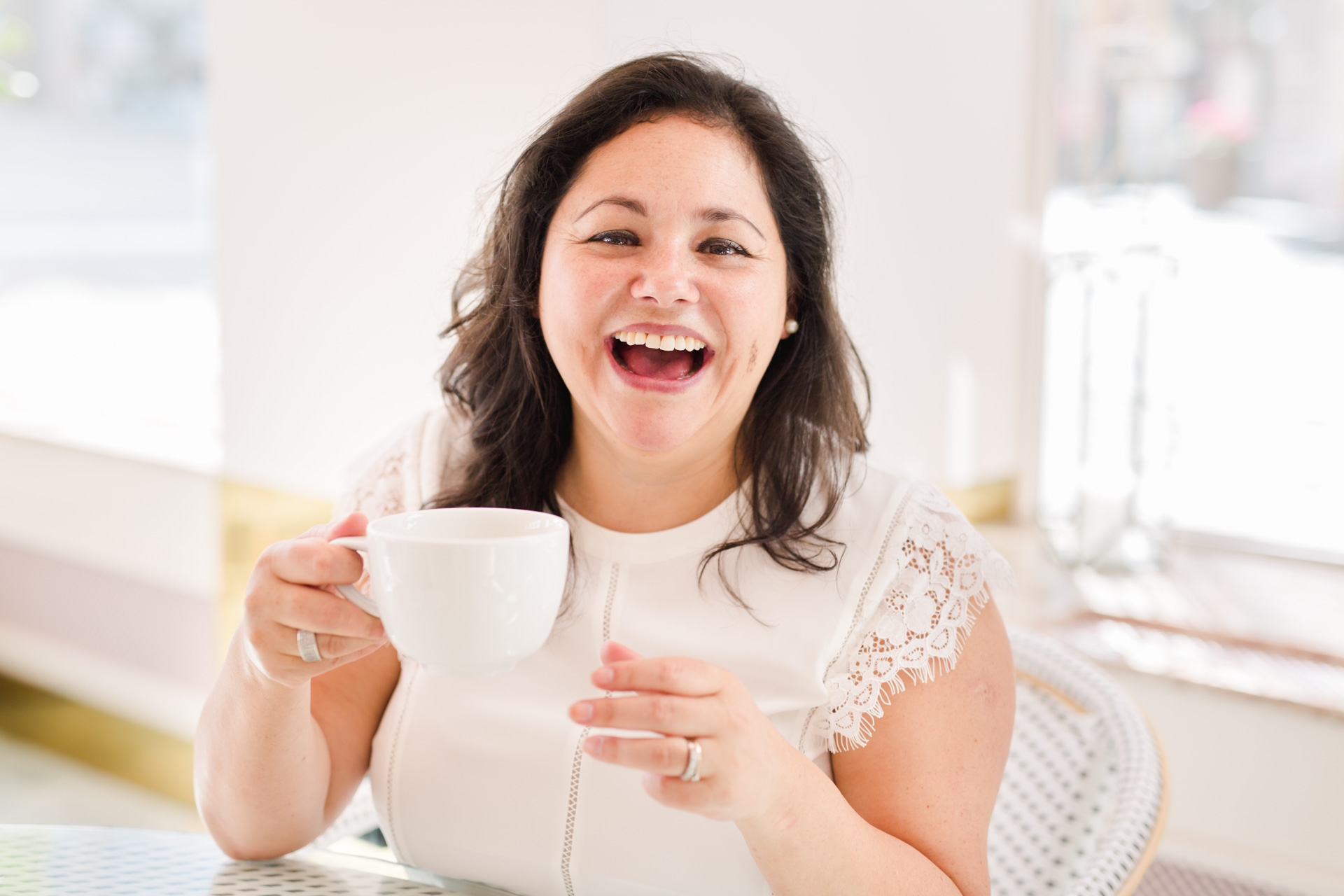 A branding photo of entrepreneur Marjorie Soto Diaz laughing and holding a cup of tea