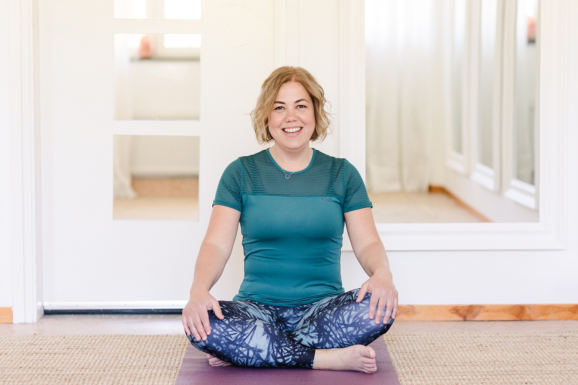 A yoga instructor sitting and smiling