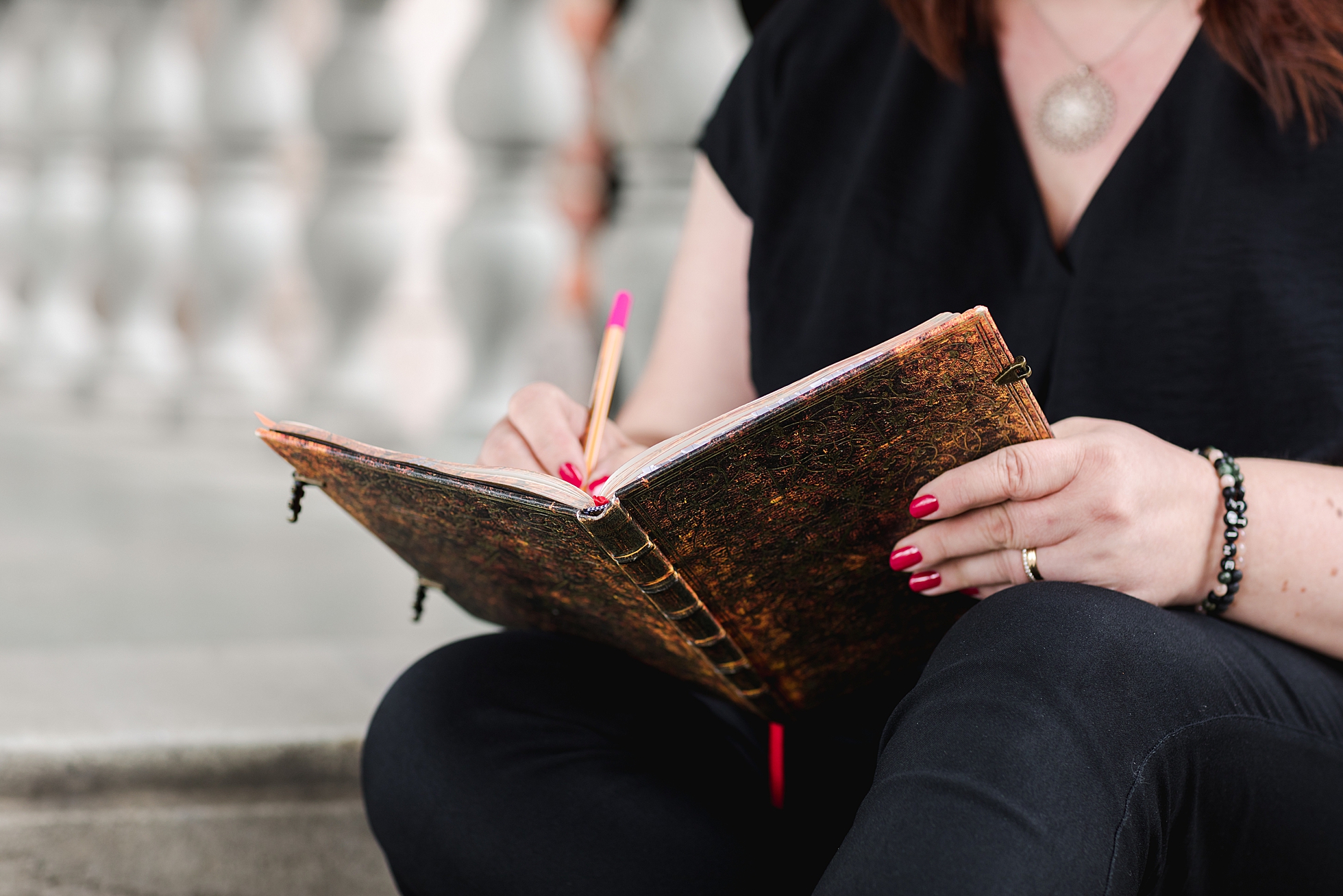 A close up photo of a woman writing in a notebook