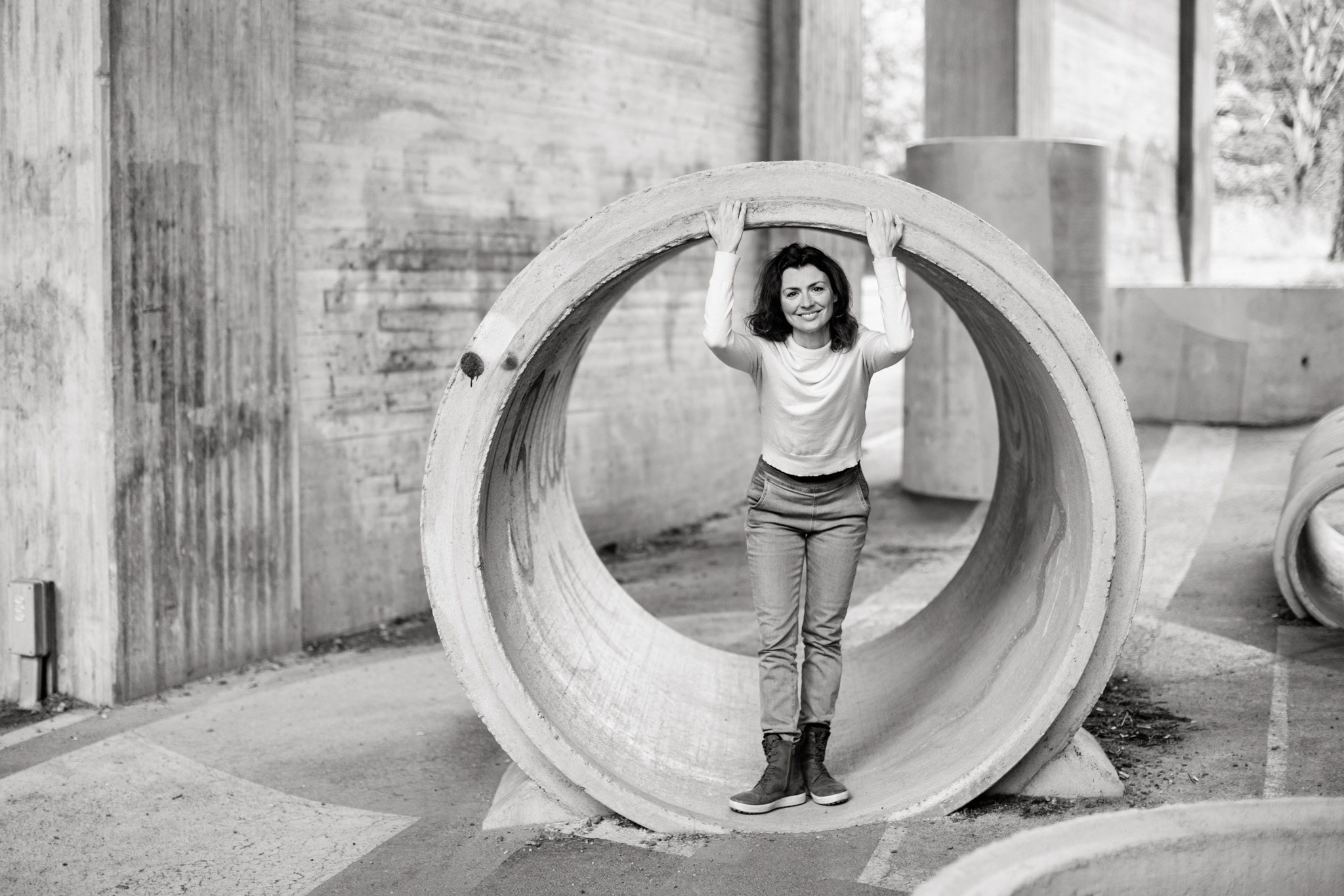 a black and white personal brand photo of writer Alexandra Mateus in a concrete tube