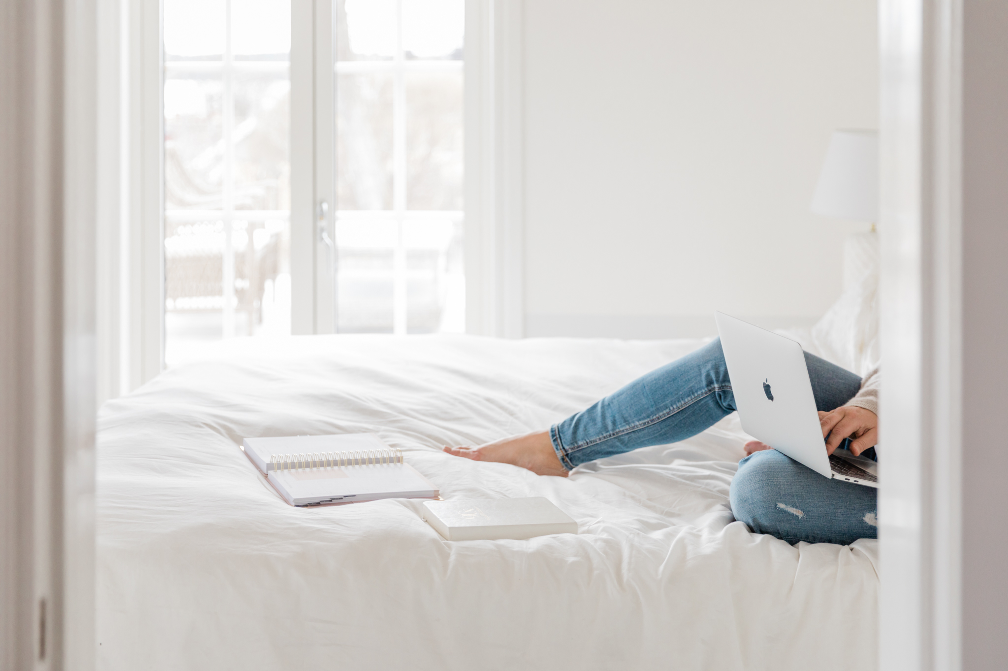 210428-MalinHB-Lumeah Photography-sociala medier-016 a business woman dressed in jeans working on her laptop while sitting on her bed