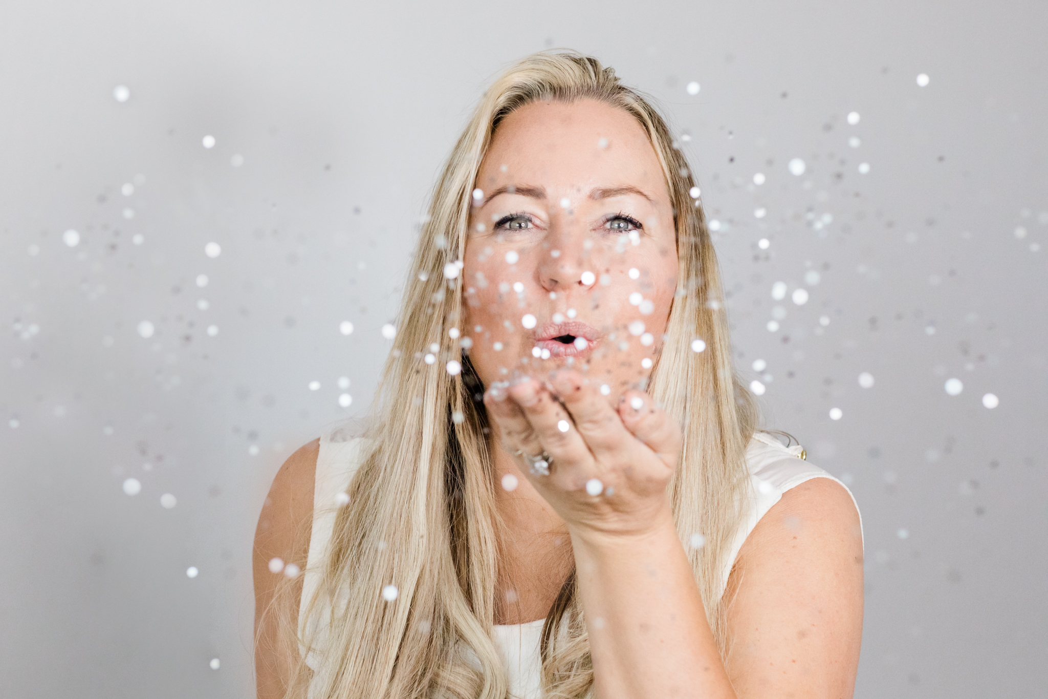 a happy energy-filled photo of brand coach Malin Hammar-Blomwall blowing glitter