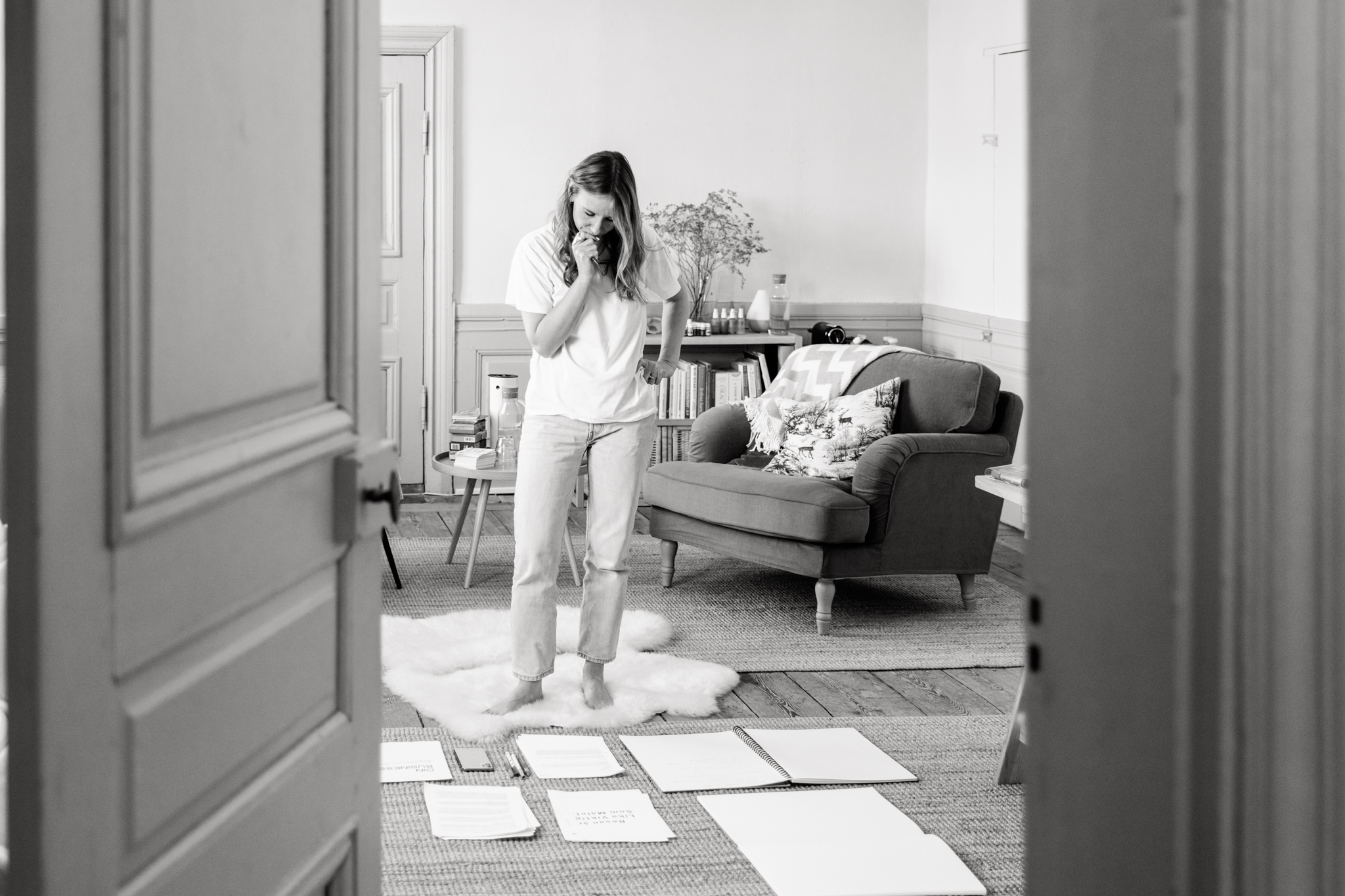 a black and white photo of coach Sara Flume standing and looking at some notes