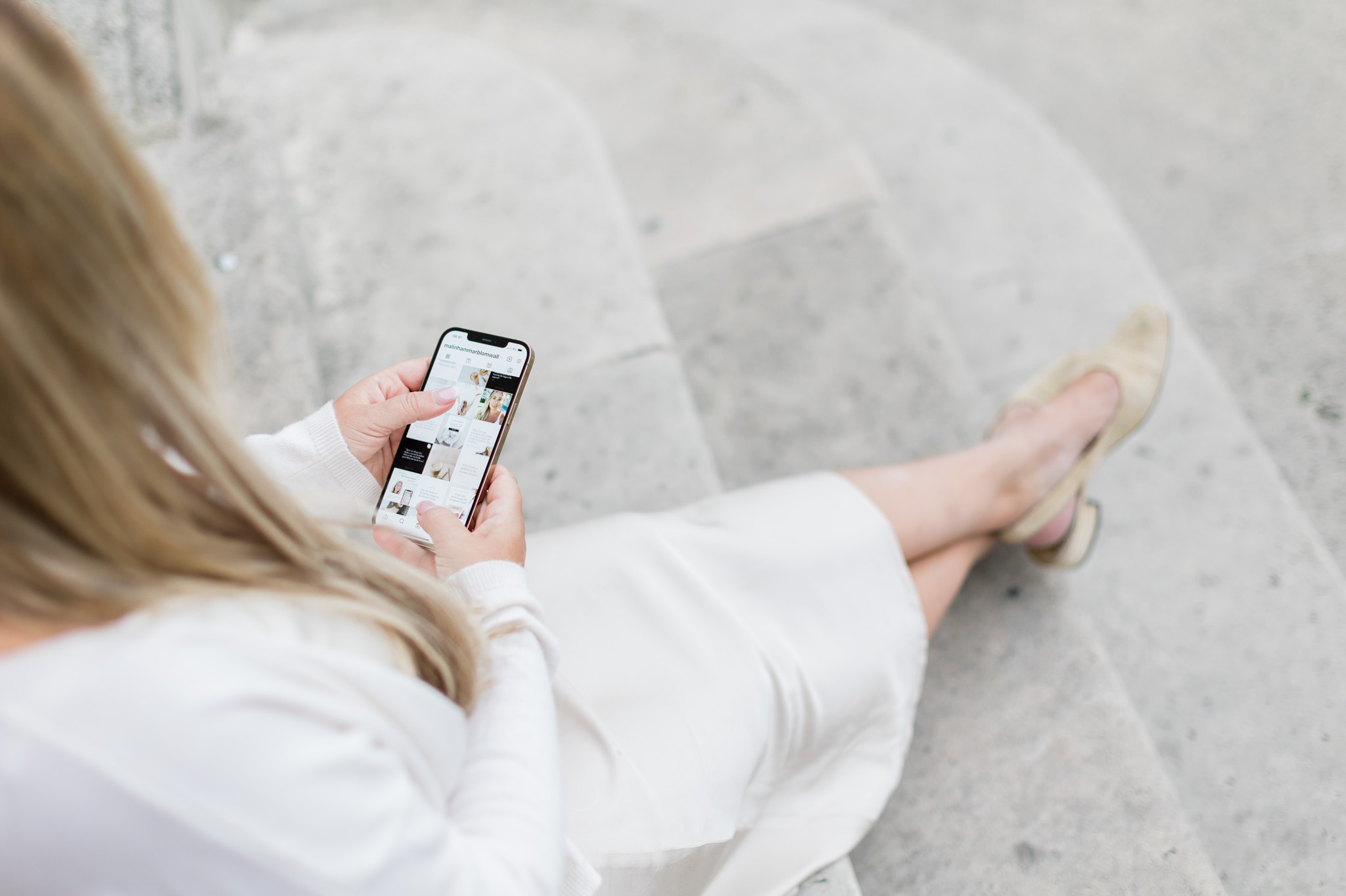 a personal brand photo of brand coach Malin Hammar-Blomwall scrolling on her mobile in Paris