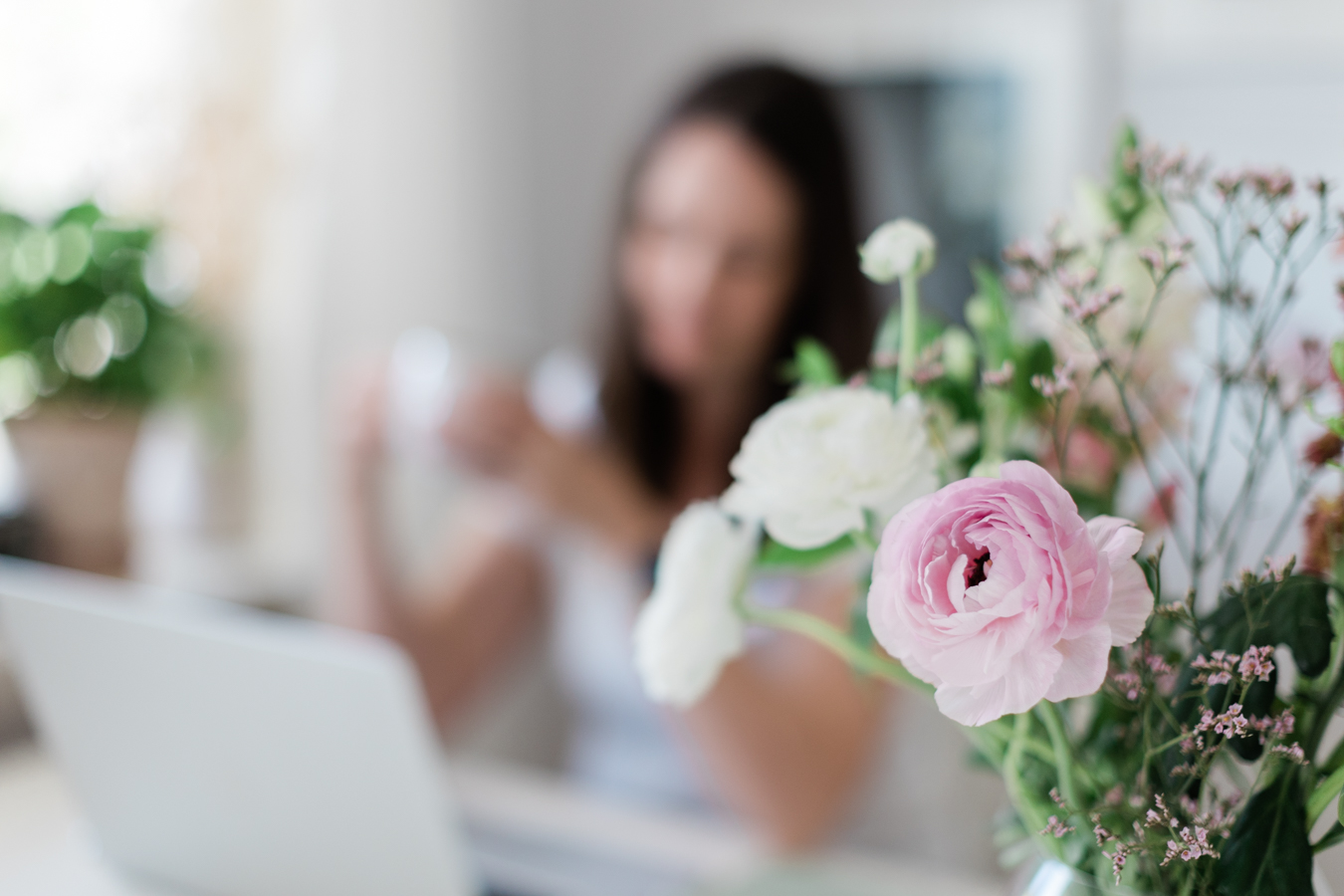 a calm photo of pink and white flowers with photographer Janine Laag blurred in the background