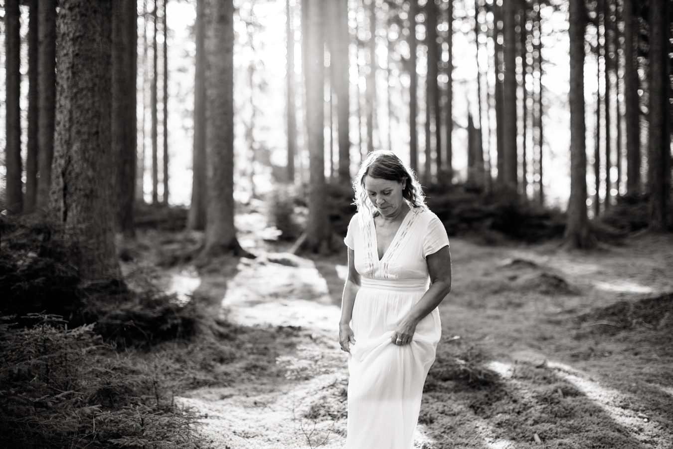 a black and white photo of coach Ulrika Hederberg walking in a forest