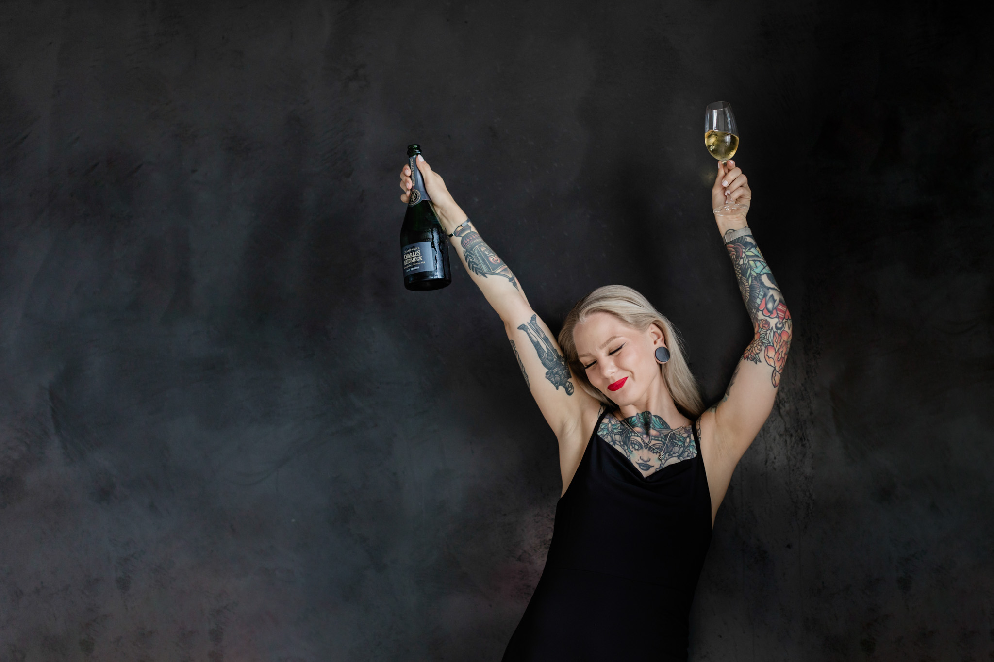 a brand photo of Katrin Berndt as she's holding a bottle and glass of champagne to celebrate a win