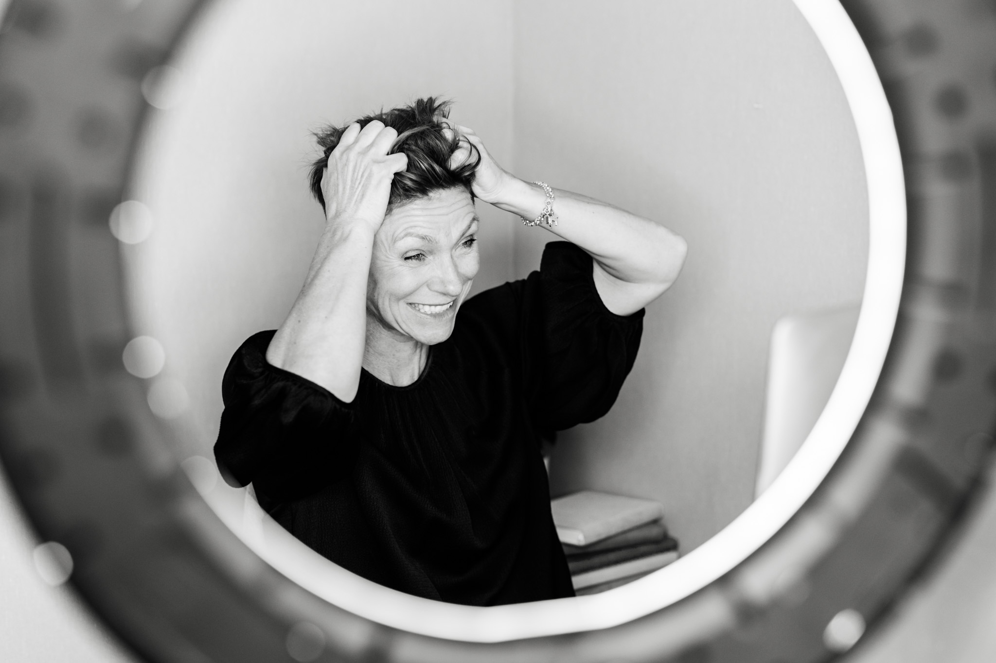 a black and white brand photo of Jill Nyqvist holding her hair in frustration while recording a webinar