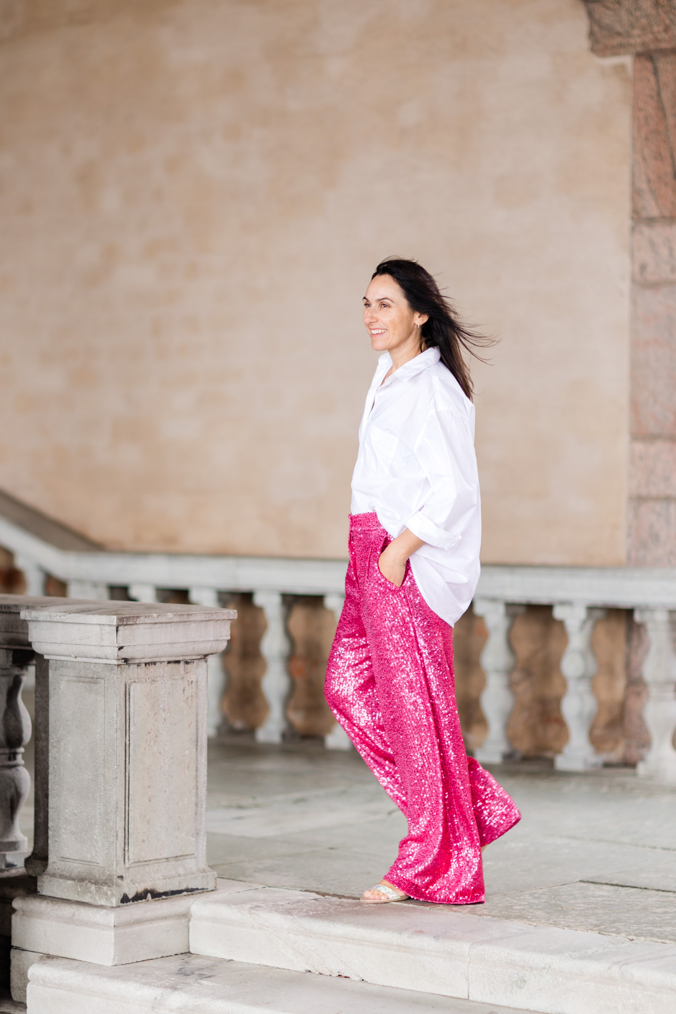 a personal brand photo of life coach Consuelo in bright pink pants at Stockholm Stadshus