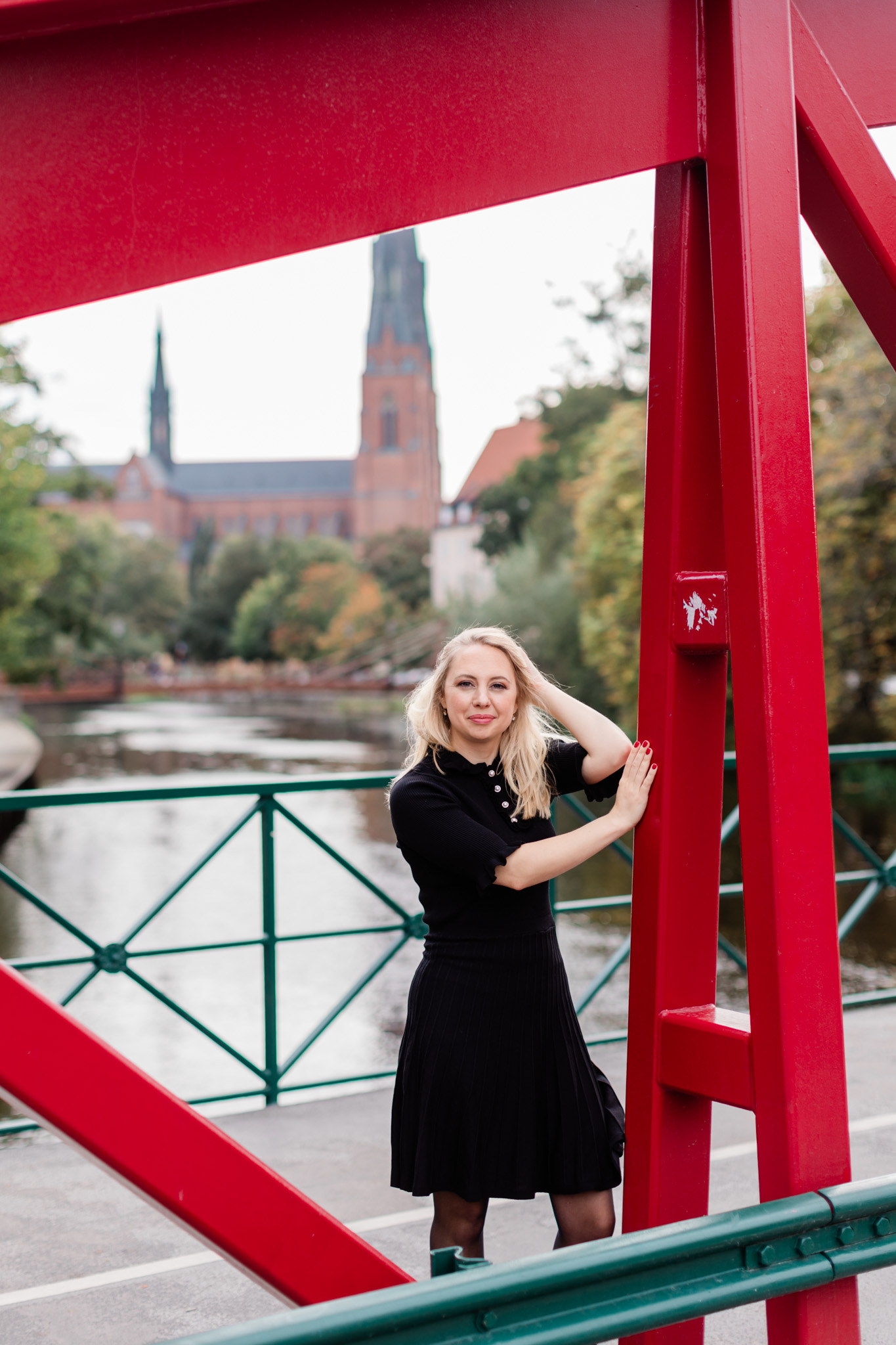a spontaneous photo of author Susanne Kleman on a bridge in front of Uppsala Cathedral