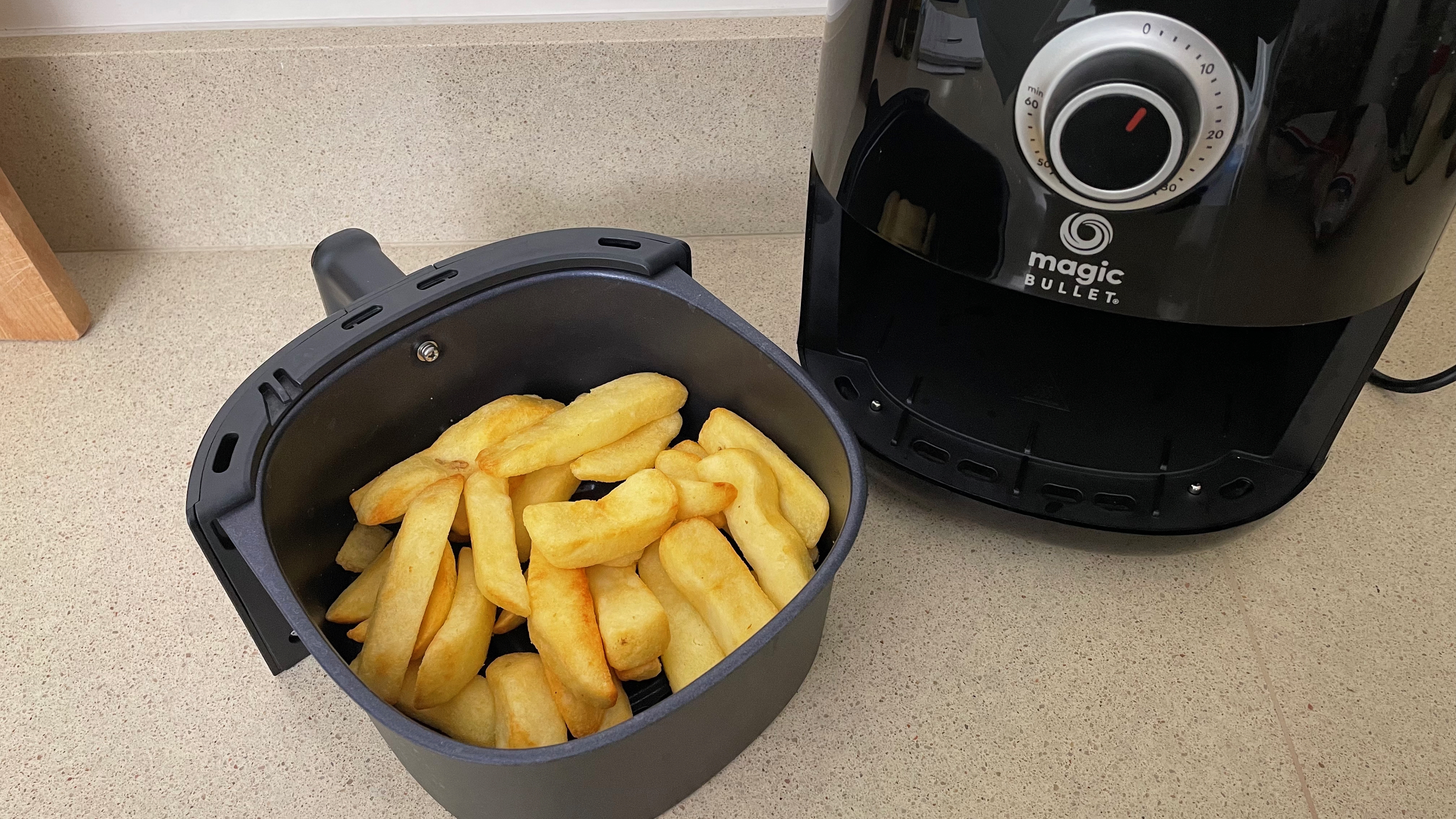 Magic Bullet Air Fryer next to tray of uncooked chips