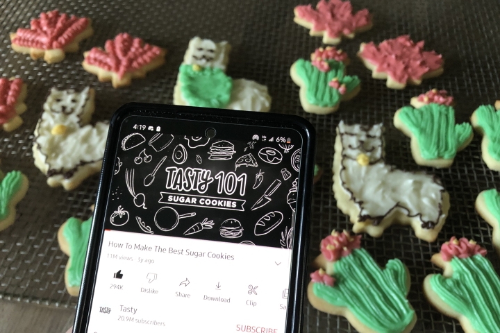 A phone playing a Youtube recipe with sugar cookies in the background.