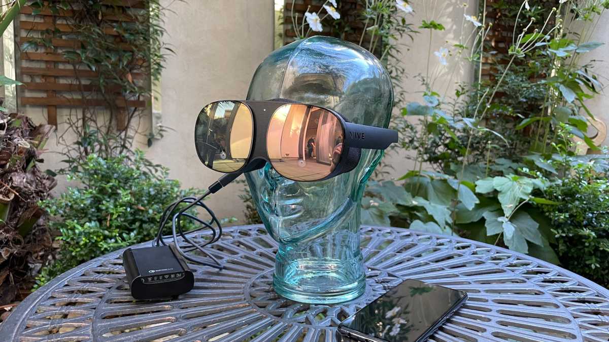 HTC Vive Flow on a glass head with smartphone and battery pack