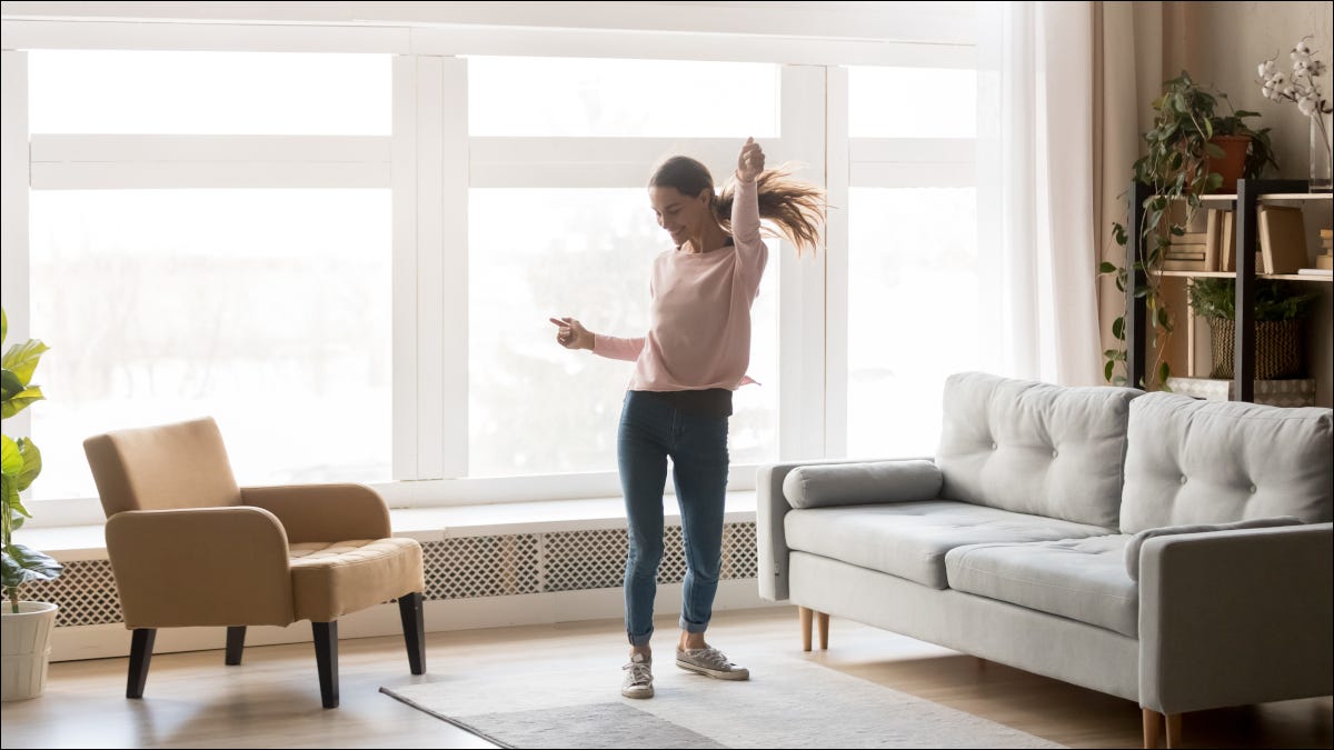 Woman dancing to music in a living room.