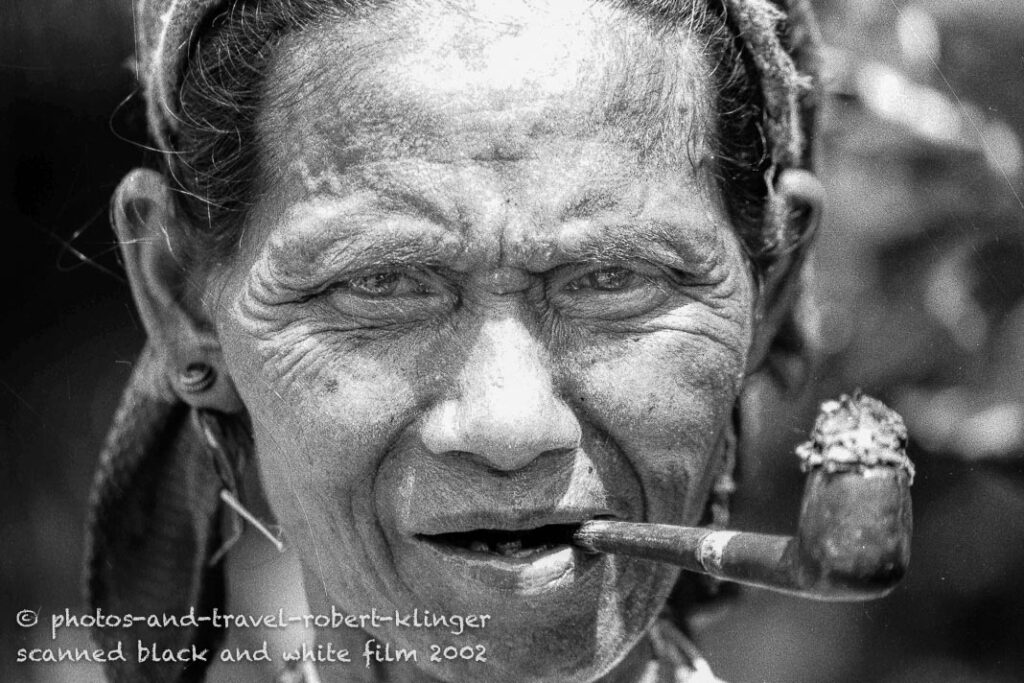 A vietnamese woman smoking the pipe