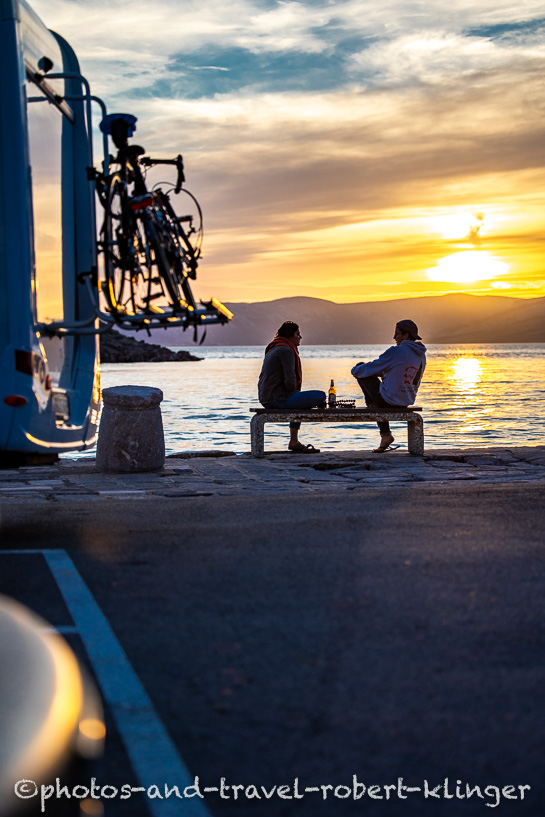 Two travellers are enjoying the sunset in Sveti Juraj, Croatia