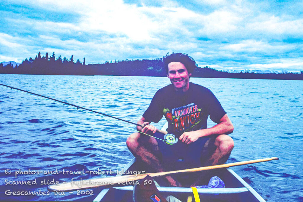 A man fishing in Alaska from a Canoe