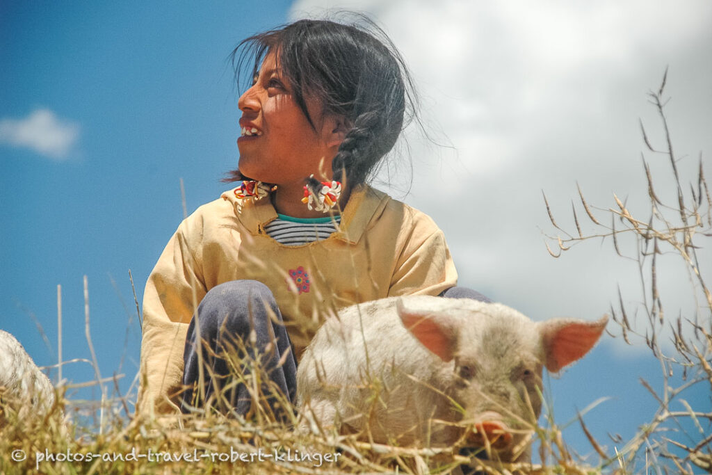A girl playing with a pig in Guatemala