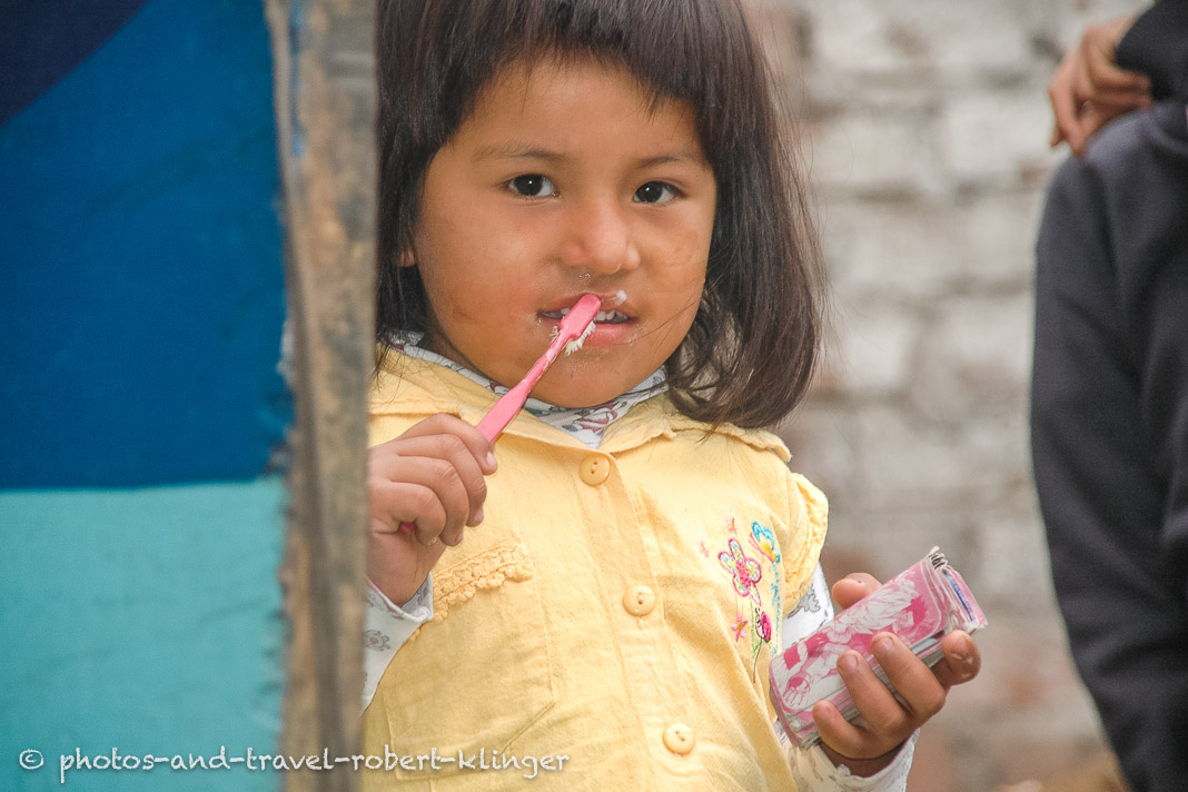 A girl in Lima, Peru, cleaning her teeth