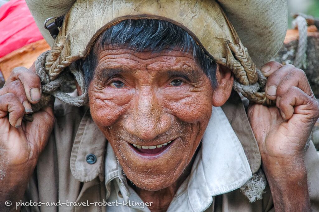The face of a older man carrying wood in Mexico
