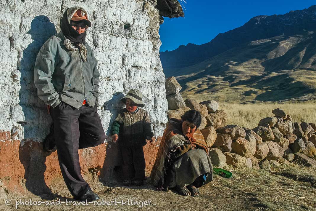 A peruan family warming up in the sun on an early morning high up in the Andes