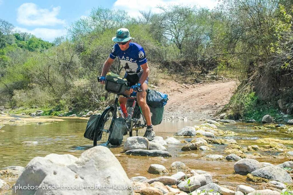 A cyclist crossing a stream in Argentina