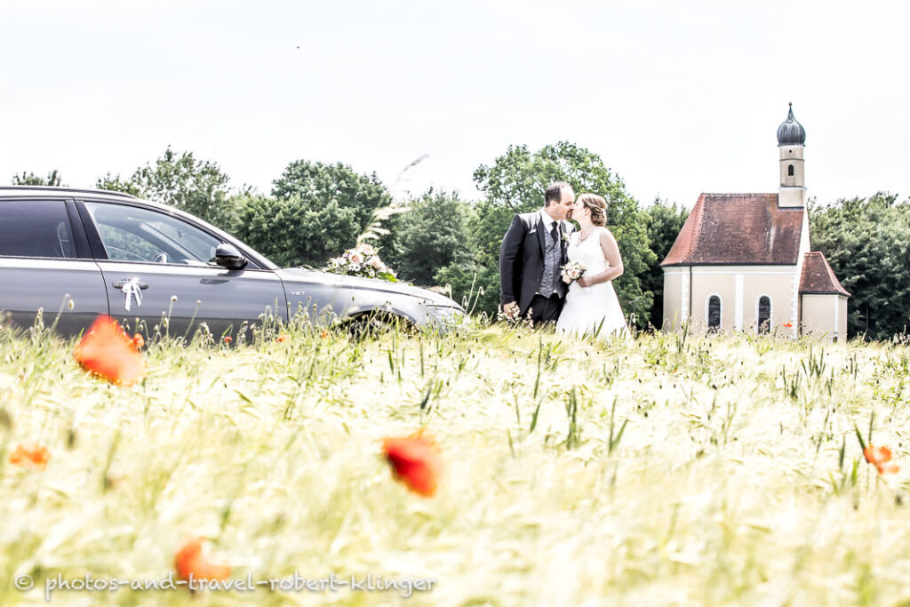 The bridal couple photographed near a church in the bavarian countryside