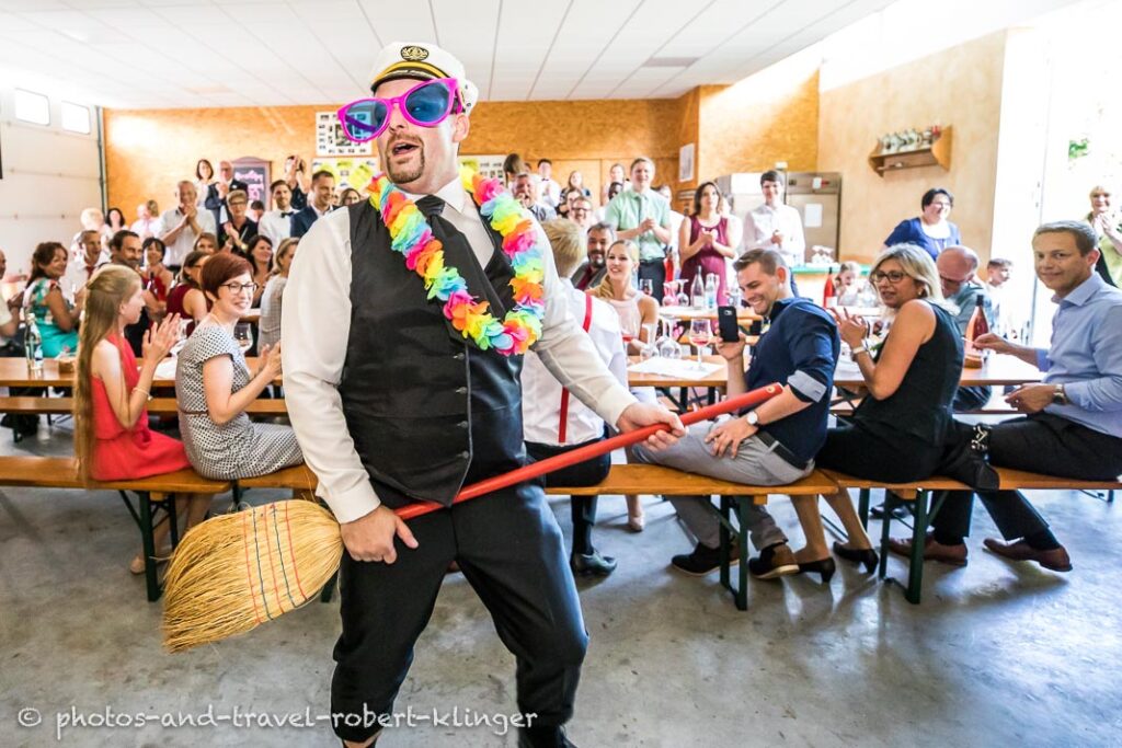 The groom dancing with a broom