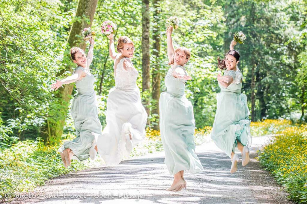 The bride and the bridesmaids jumping in the forest