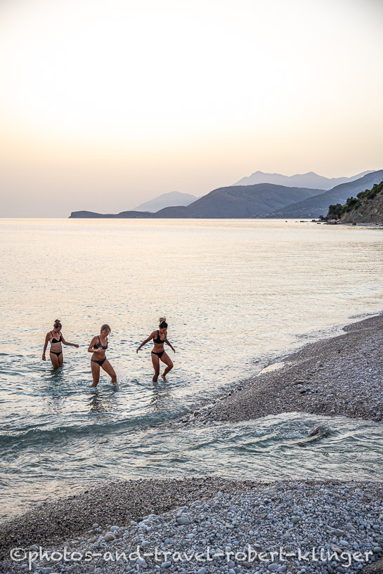 Three girls leaving the sea at a beach in Albania