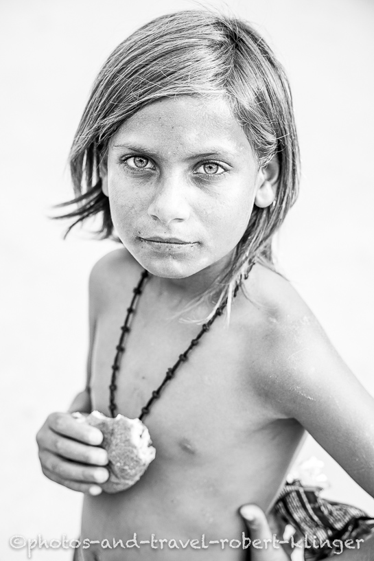 A boy in Albania is eating a piece of cake, black and white photo