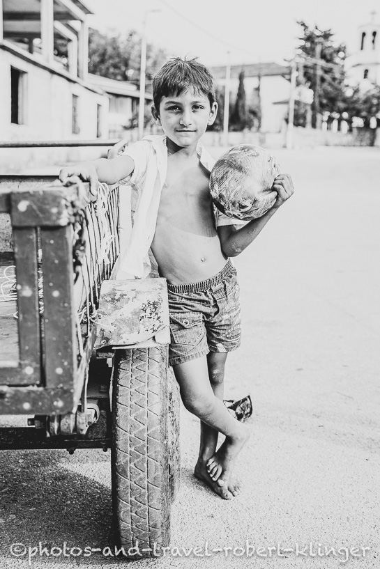 An albanian boy with a ball on a street, black and white photo
