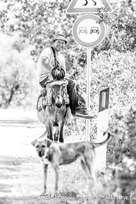 A man sitting on a donkey in Albania, black and white photo