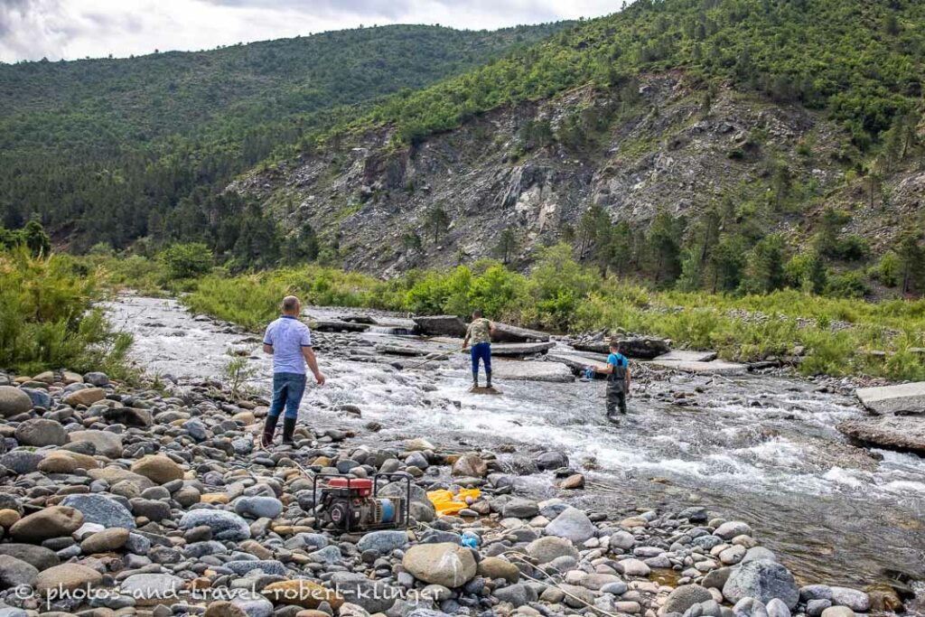 3 men fishing a stream with electricity in Albania