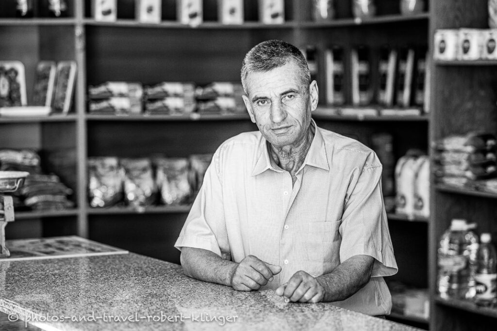 A vendor in his shop in Albania, black and white photo