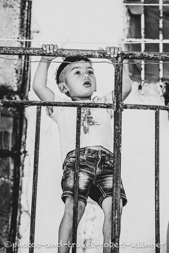 A little boy playing on his balcony, Albania, black and white photo