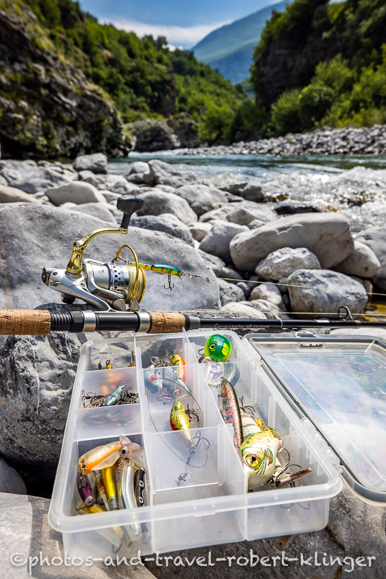 A fishing rod and a tackle box at a river in Albania