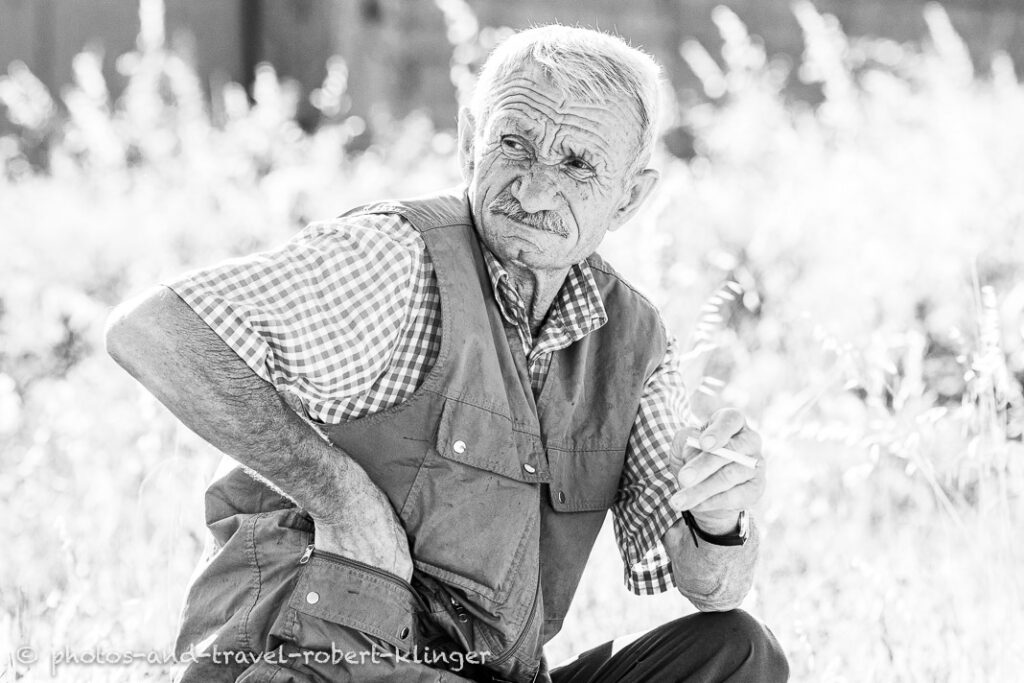 A old man preparing a cigarette in Albania, black and white photo