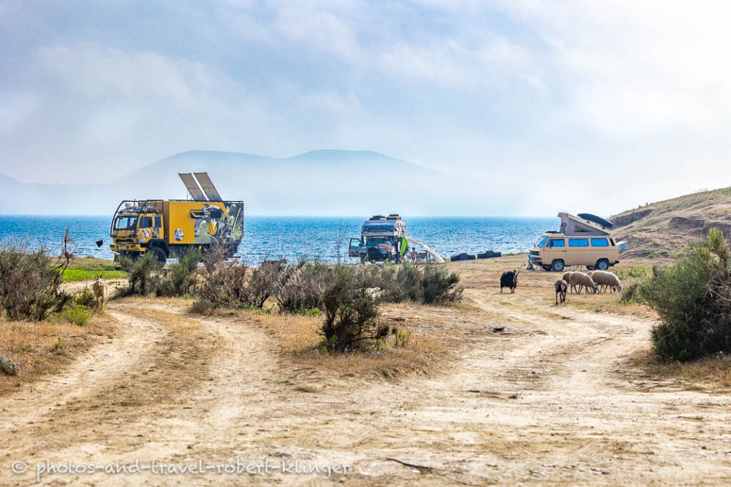 Three camping vehicles, including a expedition mobil next to the sea in Albania
