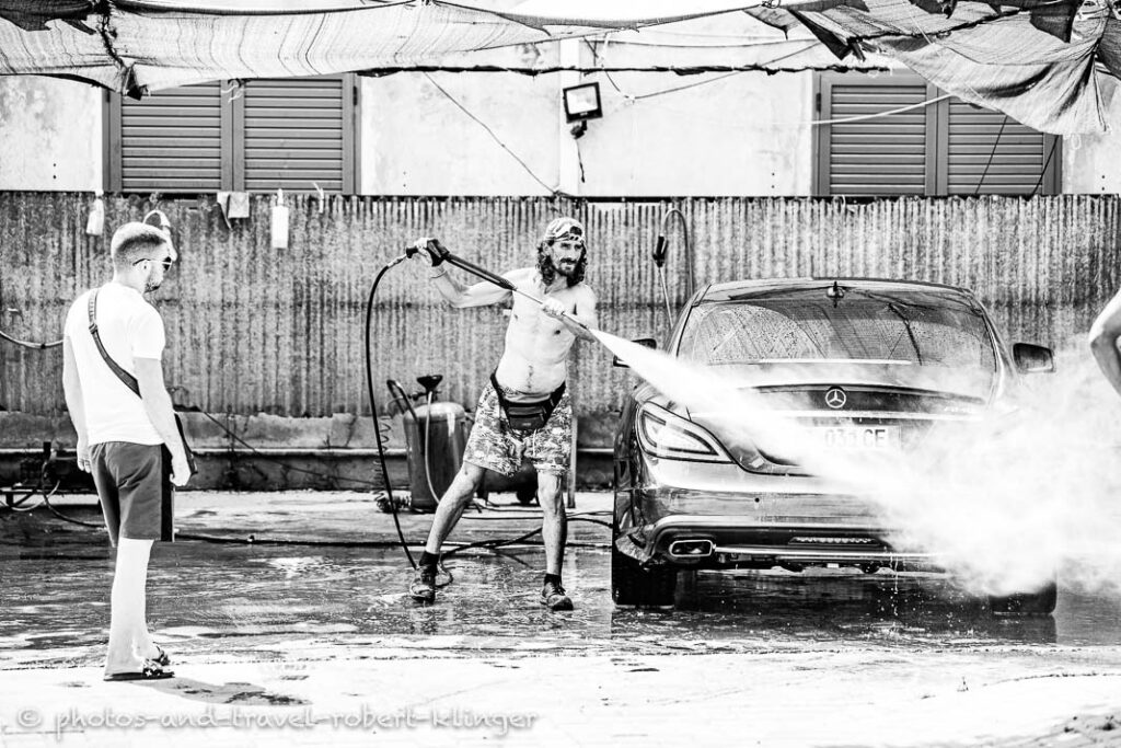 A man cleaning a mercedes in a car wash, Albania, black and white photo
