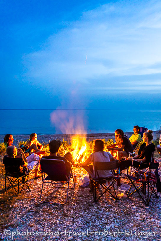 Camping tourists are sitting around a campfire in Albania
