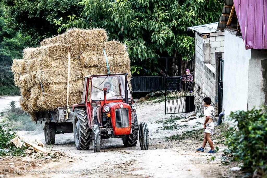 A tractor, fully loaded with straw, entering a village in Northern Macedonia