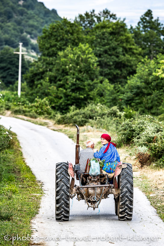 A travel photography portrait of a old happy farming couple on a tractor