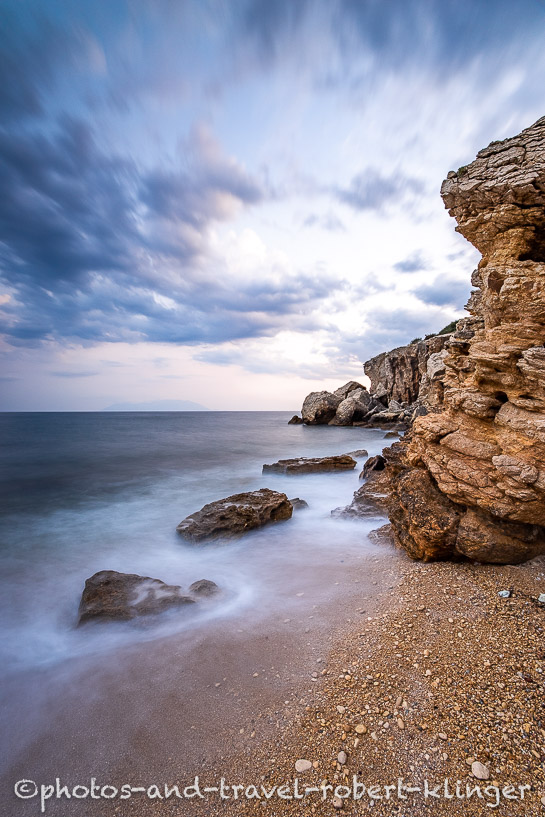 Long exposure photo of a sunset on a stony and steep shore in Greece