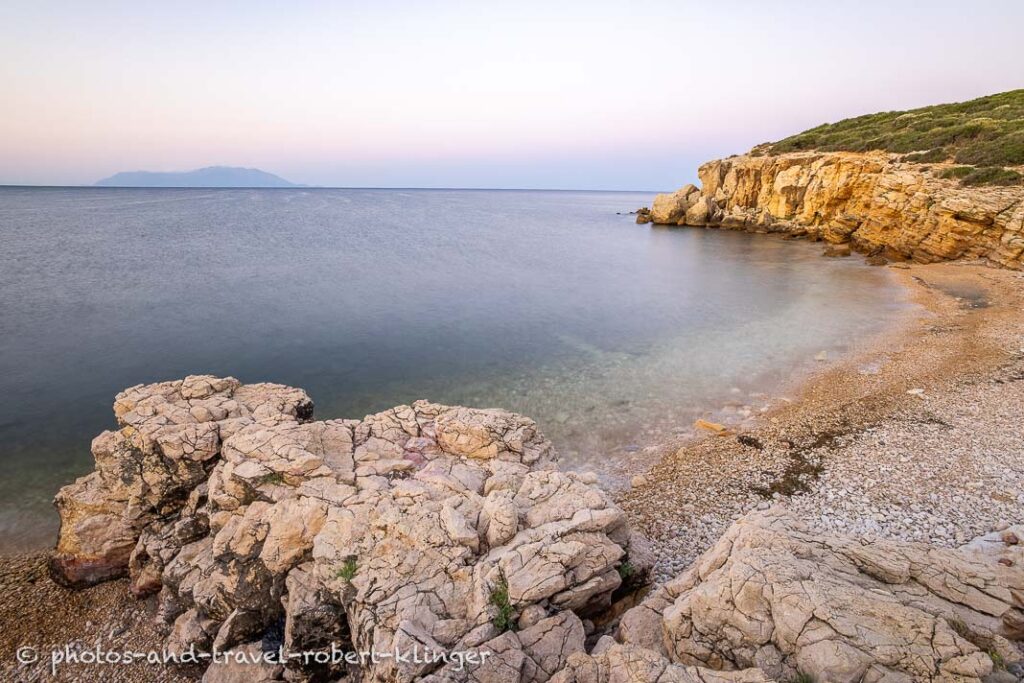 Long exposure photo of a sunrise on a stony and steep shore in Greece