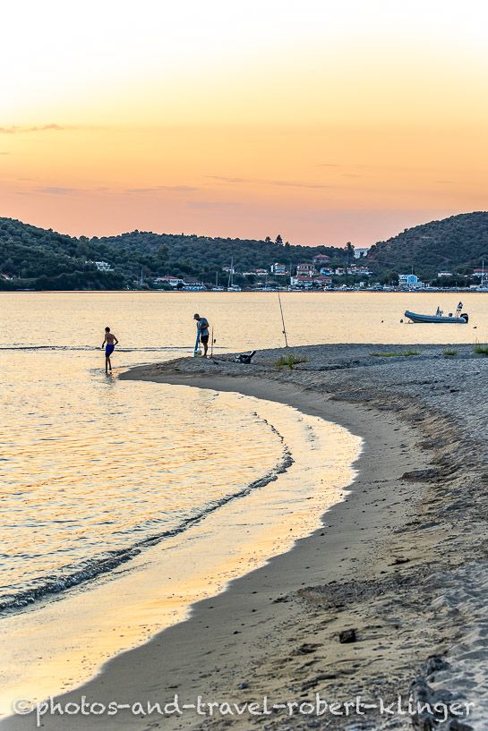 A father and his son fishing from the beach in Sithonia, Greece